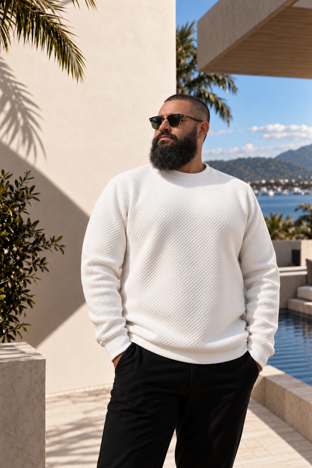 Anthony Holmes, bearded and wearing sunglasses, on a pool terrace
