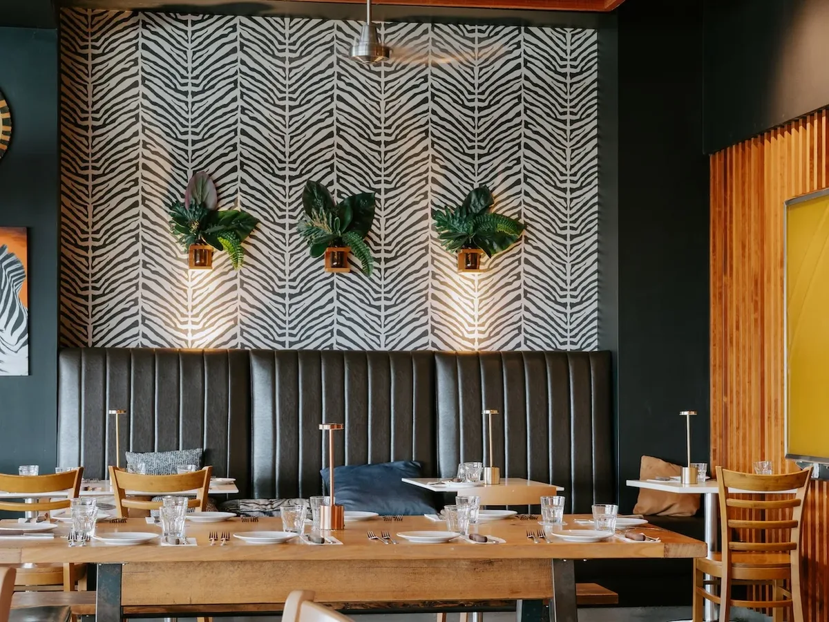 Waterbar & Grill dining room with long timber tables, leather banquette and patterned feature wall