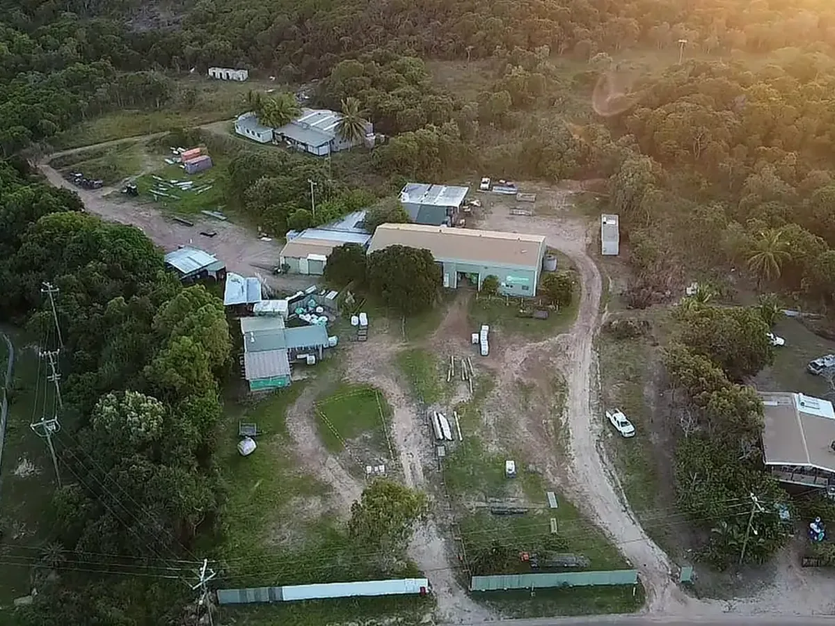 Aerial view of the Crystal Ailan site, its buildings and surrounding bushland on Badu Island